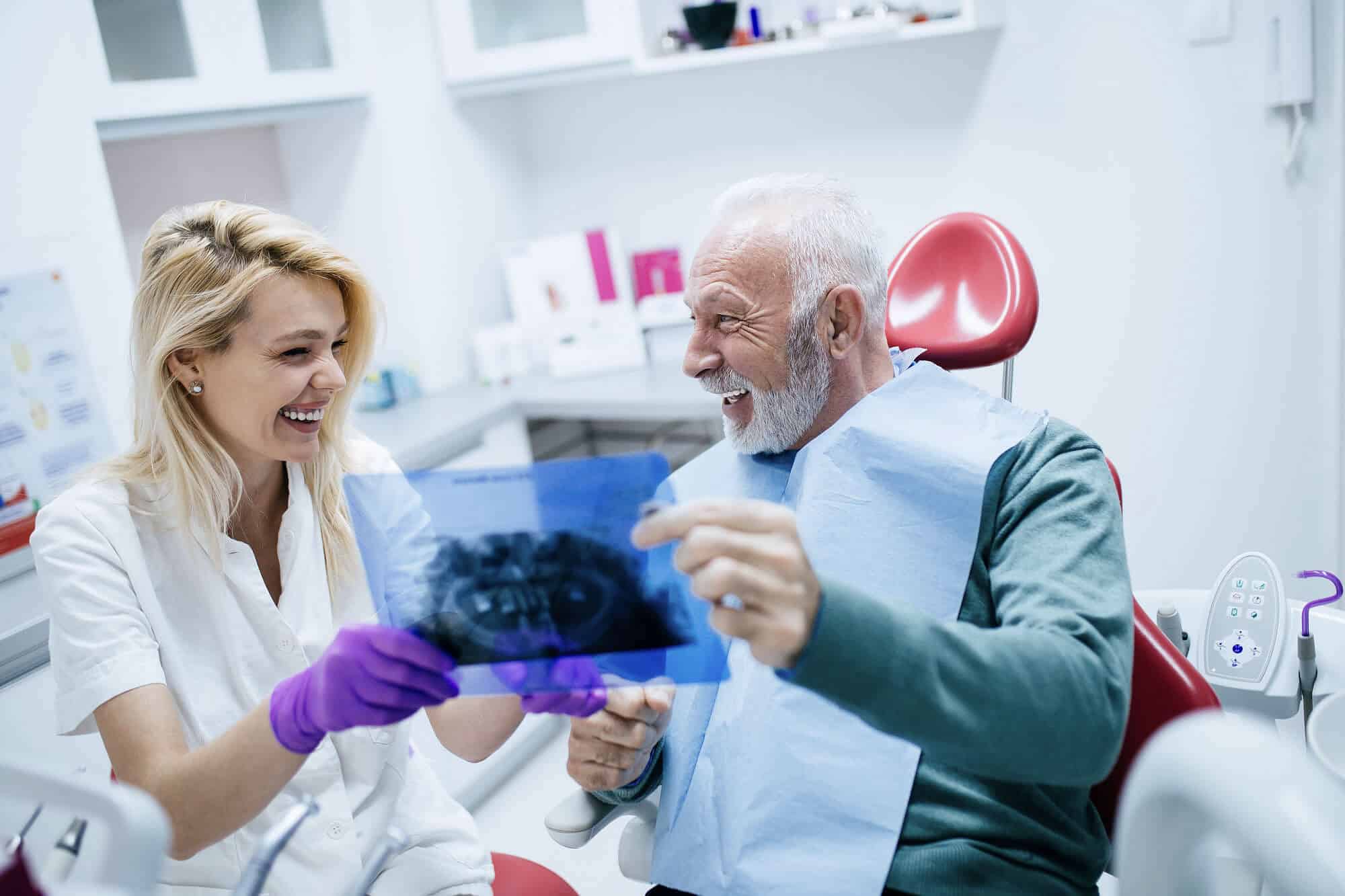 Dentist reviewing an x-ray with a patient while discussing ceramic implants