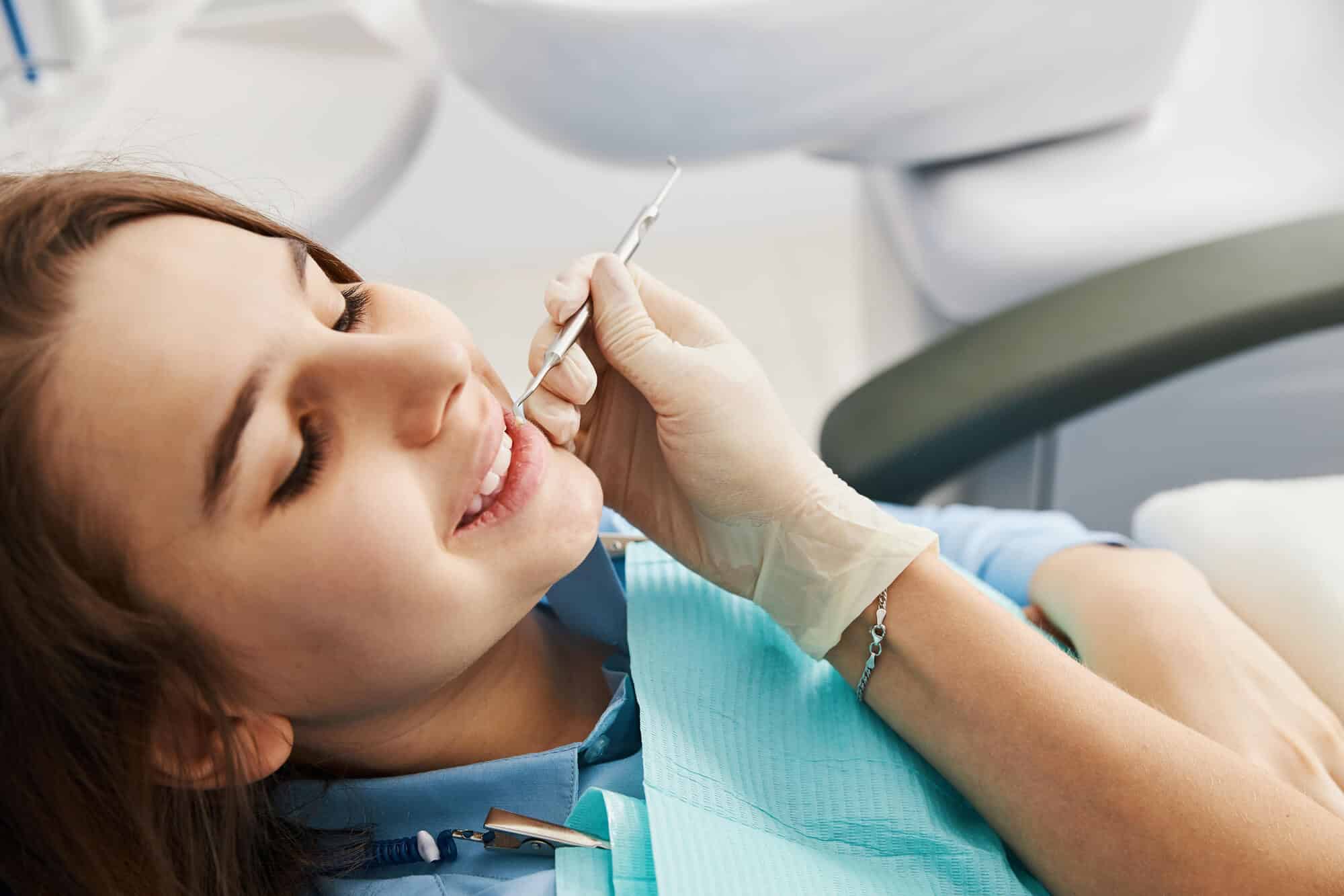 Patient having her teeth checked during a holistic cavity exam